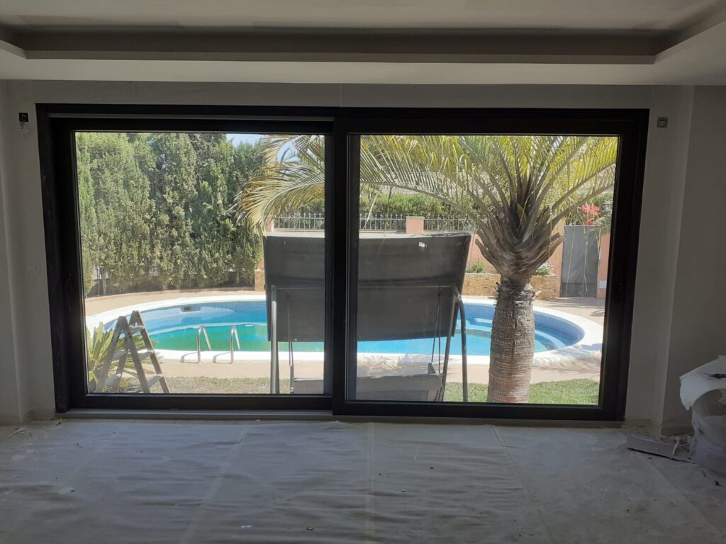 vista interior de salón con amplio ventanal de cerramiento PVC en vivienda de Mutxamel Alicante