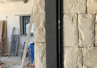 Marco de una ventana de aluminio totalmente empotrada en una hermosa pared de piedras. Los perfiles de aluminio de esta ventana están completamente integrados dentro de la pared. Un excelente trabajo de instalación de ventanas en Alicante