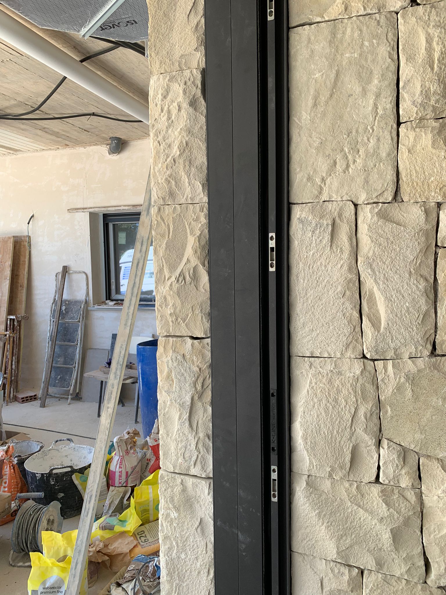 Marco de una ventana de aluminio totalmente empotrada en una hermosa pared de piedras. Los perfiles de aluminio de esta ventana están completamente integrados dentro de la pared. Un excelente trabajo de instalación de ventanas en Alicante