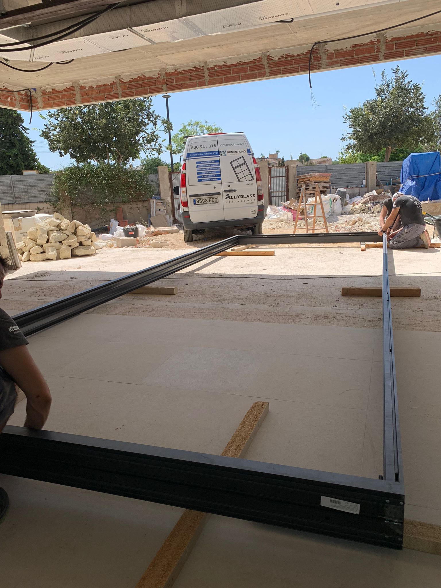 Instaladores de ventanas de aluminio en Alicante colocando marcos de una gran ventana en un chalet de san vicente del raspeig. 